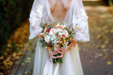 Brides wedding bouquet in women's hands. wedding flowersの写真素材
