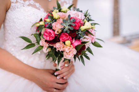 Brides wedding bouquet in women's hands. wedding flowersの写真素材