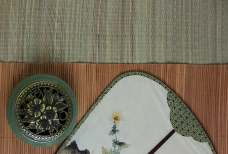 Ð¡hinese incense burner and fan on the bamboo mat background.の写真素材
