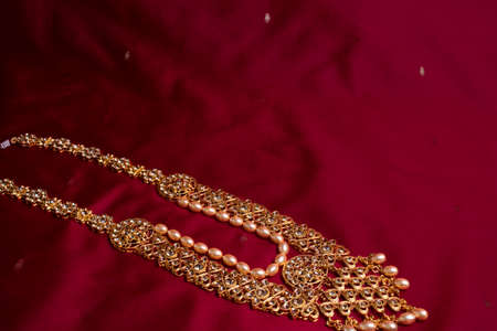 Indian traditional gold Indian wedding women's jewelry on red sari background. Close-up. Still-life.の写真素材