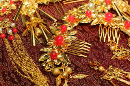 Chinese traditional hairpins hair clips Traditional Chinese women's jewelry. Gold hairpins with red gems. darck red background.の写真素材