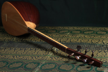 traditional Turkish national musical instrument baglama saz on a dark green background. a...