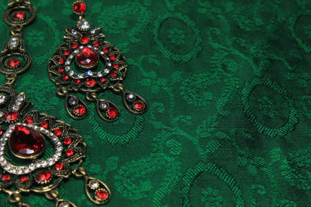 Oriental Turkish women's jewelry with red gem on a green background.の写真素材
