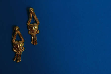 Oriental jewelry isolated on a blue background. with the image of a heart a symbol of love. Valentine's day gift Arabic, Indian, Moroccan gold.の写真素材