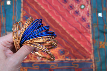 Indian blue bracelets on the background of a traditional patchwork carpet. Indian background.の写真素材