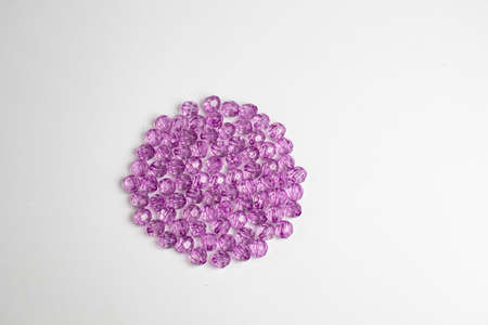 purple plastic beads on a white, gray backgroundの写真素材