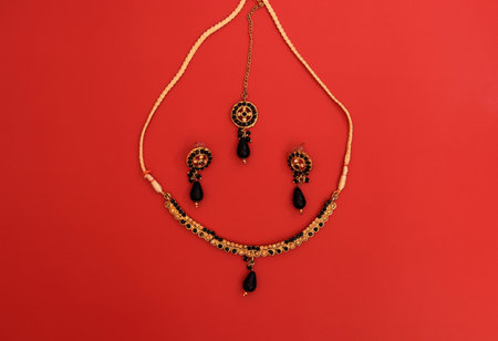 Traditional Indian jewelry is gold with black gems. Necklace, earrings, tika.の写真素材