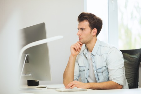 A young programmer is looking at the camera. The graphic designer is thinking about the future...