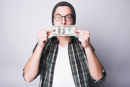 Man has money and he is satisfied. Guy is kissing 100 dollars banknote and making wish to have more