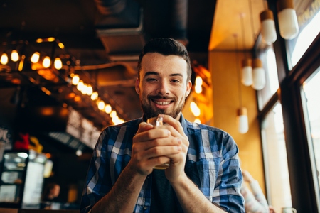 Handsome natural man looking at the camera and drinking teaの写真素材