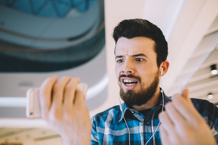 Portrait of a young handsome man with phone and headphones in urの写真素材