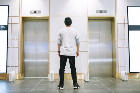Man in hat standing near the elevatorの写真素材
