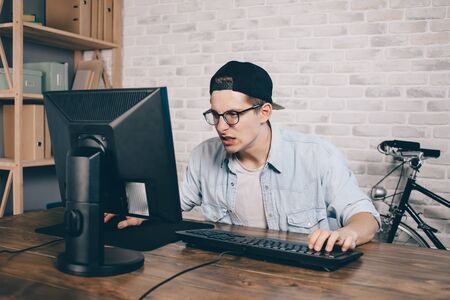 Young man playing game at home and streaming playthrough or walkthrough videoの写真素材