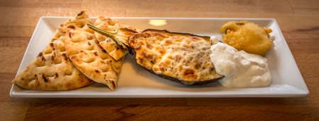 Cooked eggplant on plate with breadの写真素材