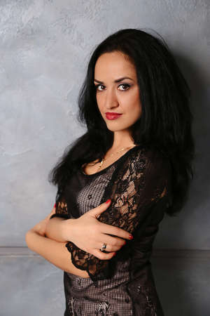 girl in evening dress on wall background. Ethnicity European girls. hands visibleの写真素材