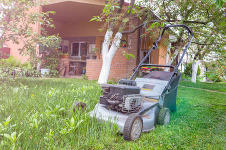 lawn mower in the garden the background house