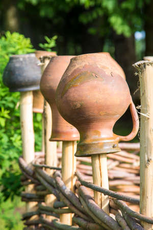 old pitcher hangs on wooden fenceの写真素材