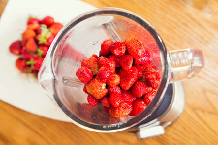 strawberries in a blender. the background white dish and tableの写真素材