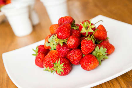 Fresh strawberries on a white dishの写真素材