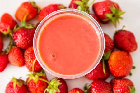Strawberry cocktail in a plastic glass. the background whole strawberriesの写真素材