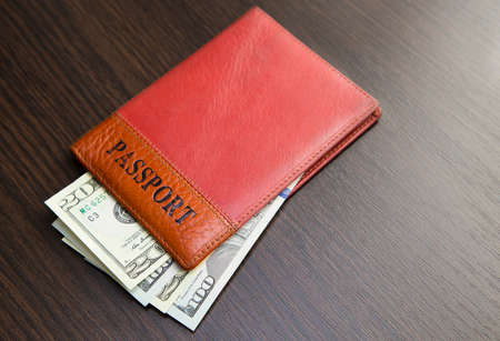 Passport with money lying on a wooden tableの写真素材