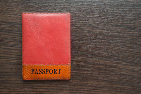 passport  in orange leather cover on a tableの写真素材