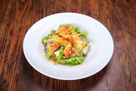 in a plate on a table with chips salad, iceberg lettuce, mushrooms, pumpkin seeds.の写真素材