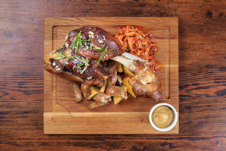 on the table board with cooked shank, potatoes and sauerkraut, mustard. top viewの写真素材