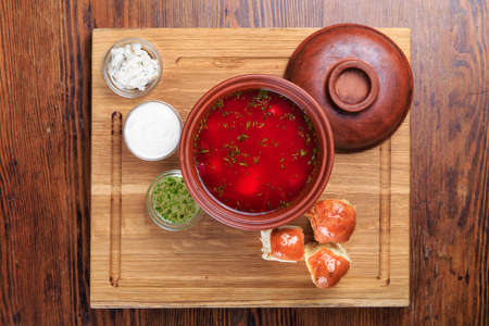 On the table is a plate of the Ukrainian borsch, biscuits, gravy boat with sour cream, bacon milled, and garlic sauce.  top viewの写真素材