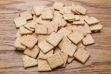 a pile of crackers is on a wooden table