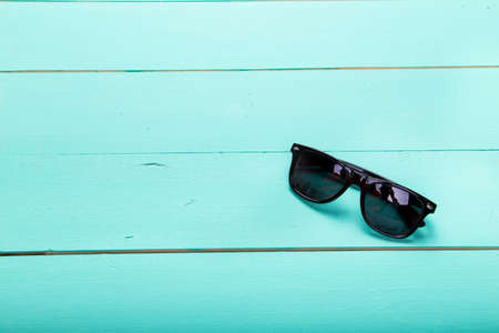 Sunglasses on wooden turquoise background, minimalism, top viewの写真素材
