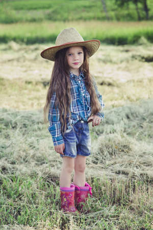 in the field is beautiful little girl with flowing hair cowboy