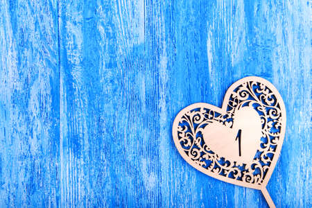 wooden heart carved on a blue wooden background. space for textの写真素材