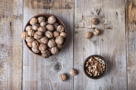 walnuts in a bowl on a wooden backgroundの写真素材