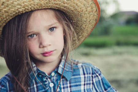 in the field is little beautiful girl Cowboy. facial portraitの写真素材