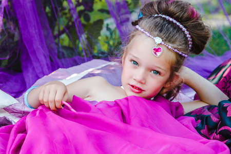 small European girl in oriental dress, crimson color, in a tent outdoors, harmony, staged shootingの写真素材