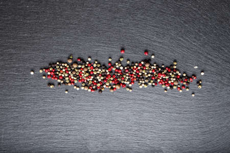 colored peppers scattered on the slate, top viewの写真素材