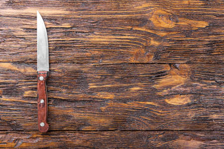 Knife on a wooden board, top view, space for textの写真素材