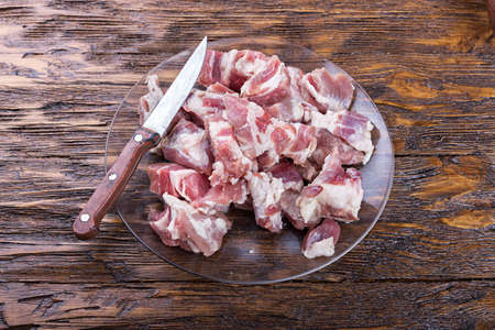 diced bacon raw meat in a plate, on a wooden boardの写真素材