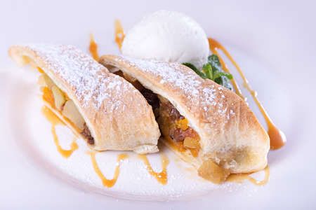 apple strudel with ice cream, dusted with powdered sugar and garnished with mintの写真素材