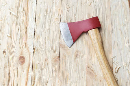 Red ax on a wooden background, top viewの写真素材
