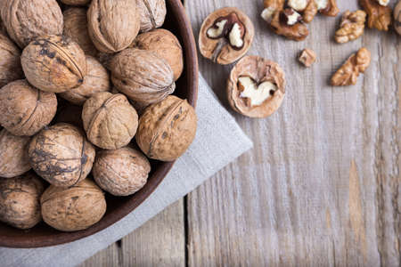 walnuts in a clay plate on a wooden background. top view