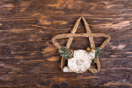 New Year's and Christmas. Christmas toy star of vines on a brown wooden table.の写真素材