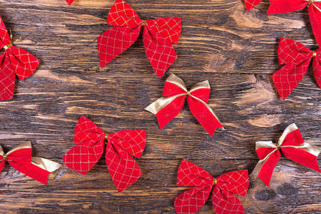 many red Christmas bows on a wooden table, Christmas tree decoration, Christmas moodの写真素材
