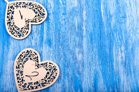 wooden heart carved on a blue wooden background. space for textの写真素材