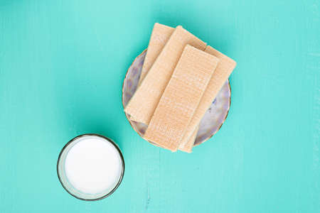 sweet crunchy waffles and milk in a glass on a blue wooden background. tasty breakfastの写真素材