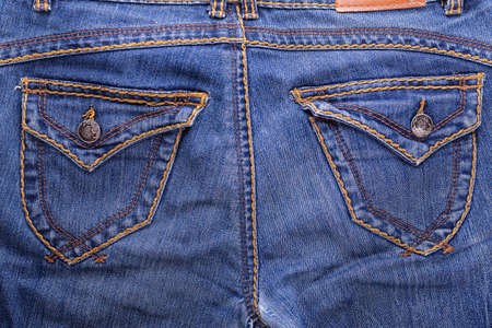 pocket of blue shabby jeans with stitching