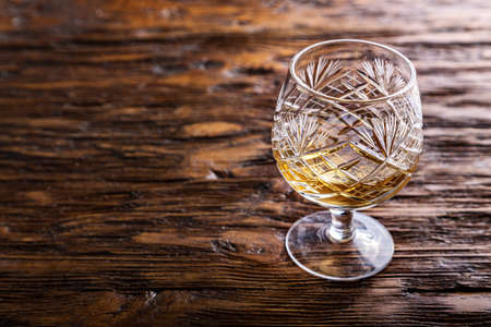 crystal glass with cognac on a wooden background, evening relaxationの写真素材