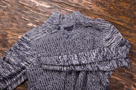 warm gray melange men's winter sweater on a wooden backgroundの写真素材
