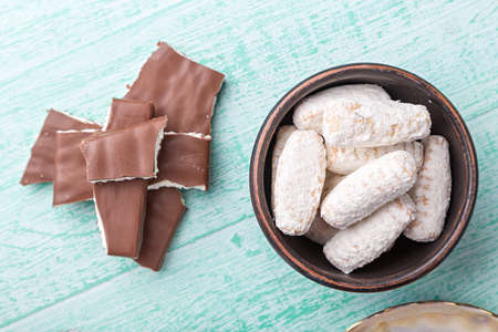 pieces of chocolate lined tower and cookies in powdered sugar on a wooden tableの写真素材